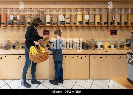 Eine Frau und ein Junge stehen vor einem Regal mit Abfüllbehältern für Getreide im verpackungsfreien Laden „Frau Erna`s loser LebensMittelpunkt“ in Ma Stock Photo